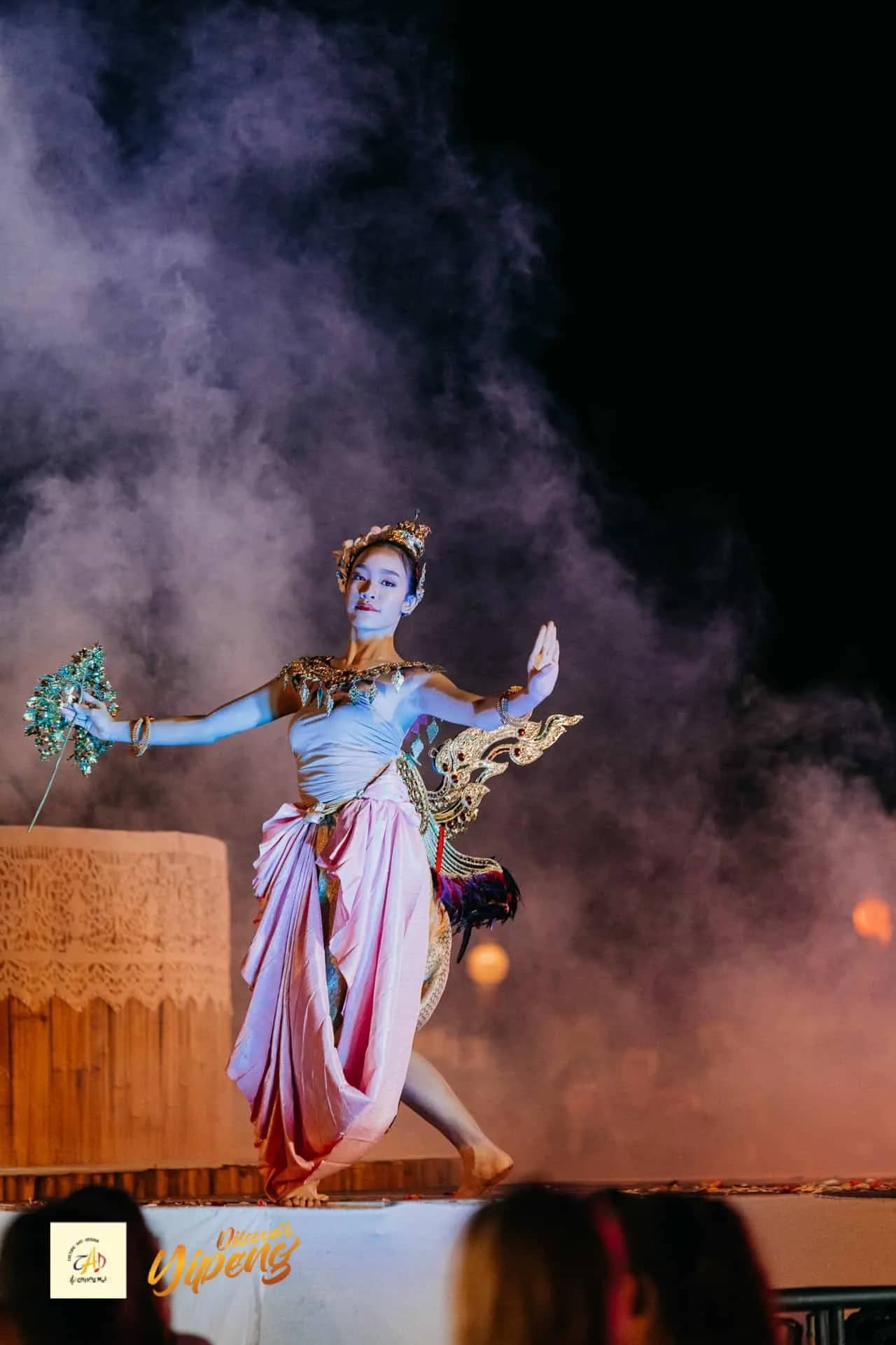 A dancer in an ornate costume performs on a smoky stage at the CAD lantern festival