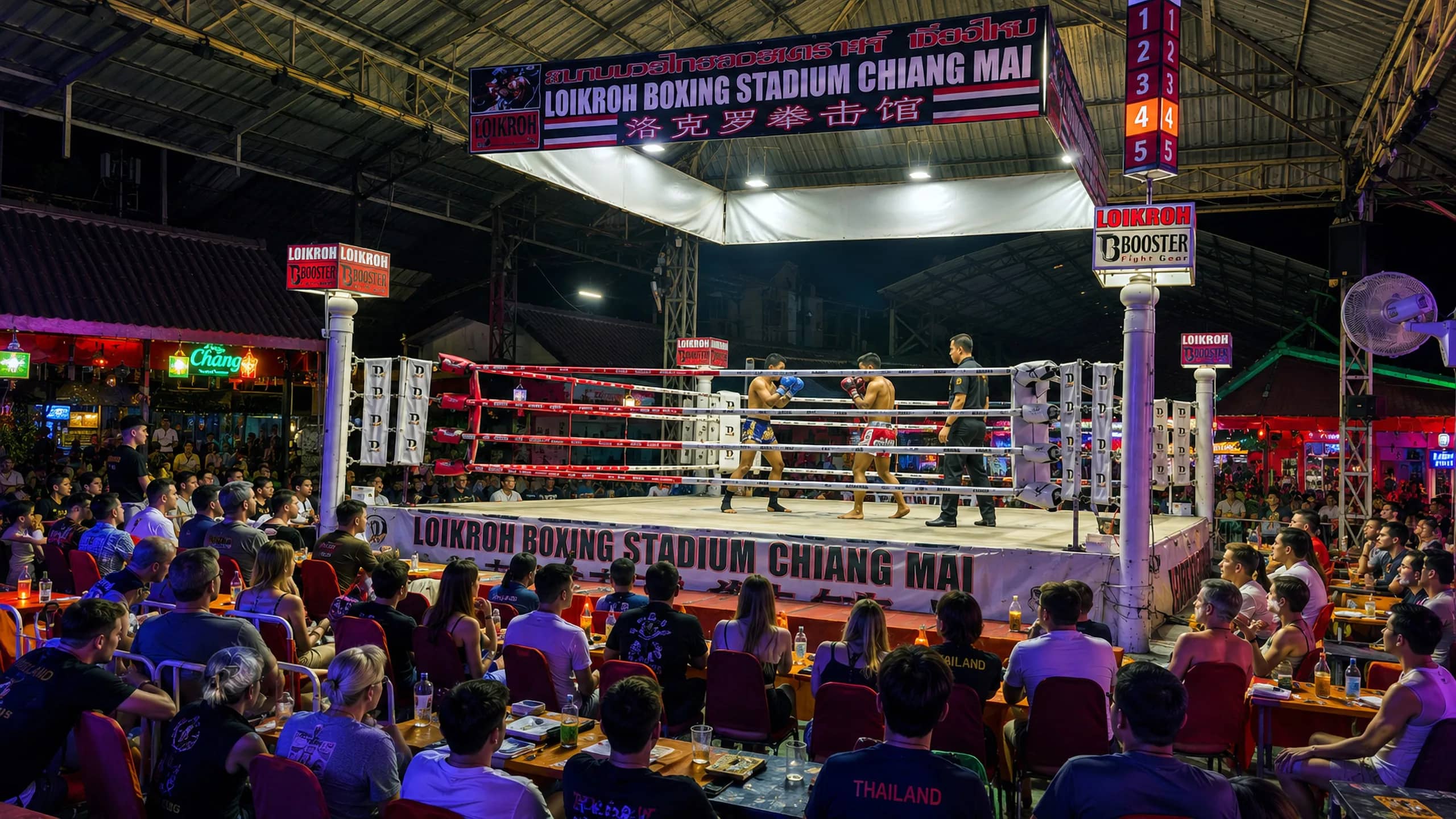 Spectators at tables watch a Muay Thai bout under the lights of Loi Kroh Boxing Stadium in Chiang Mai