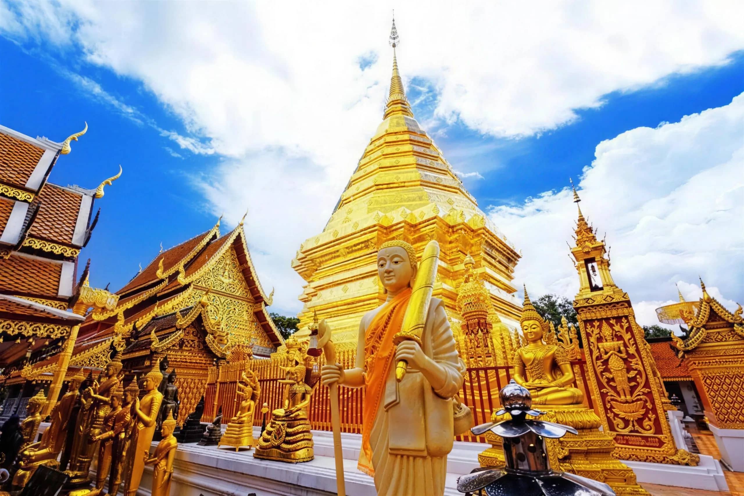 Golden Buddha statues and ornate shrines surround the glittering chedi at Wat Phra That Doi Suthep.