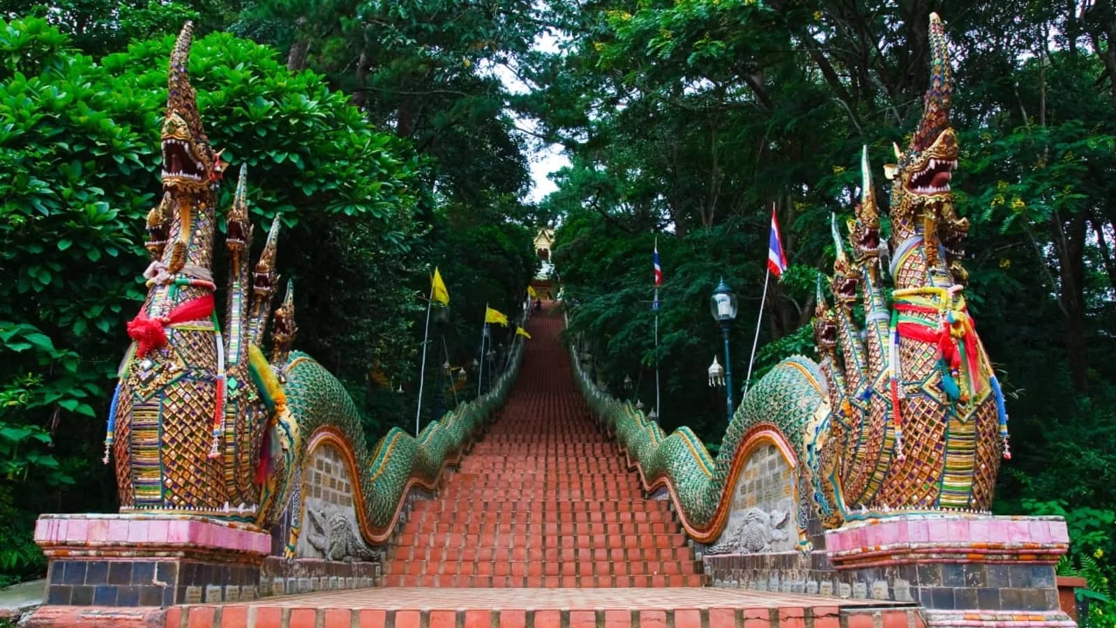 Two naga serpent statues flank the long red staircase climbing to Wat Phra That Doi Suthep.